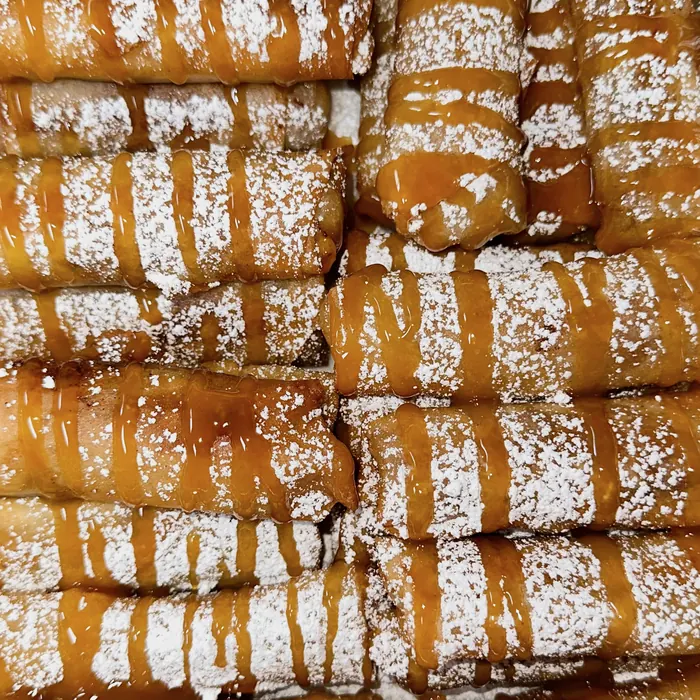 Tray of banana lumpia with caramel and powdered sugar