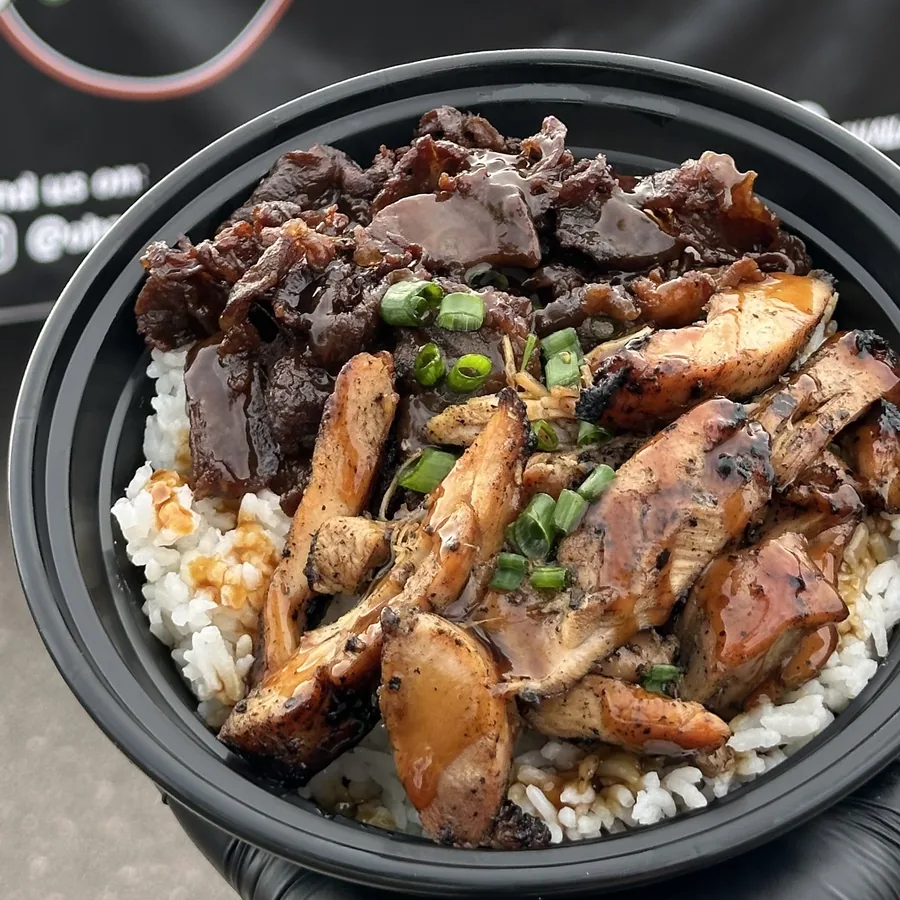 Mixed teriyaki bowl held in front of the Ohana BBQ trailer