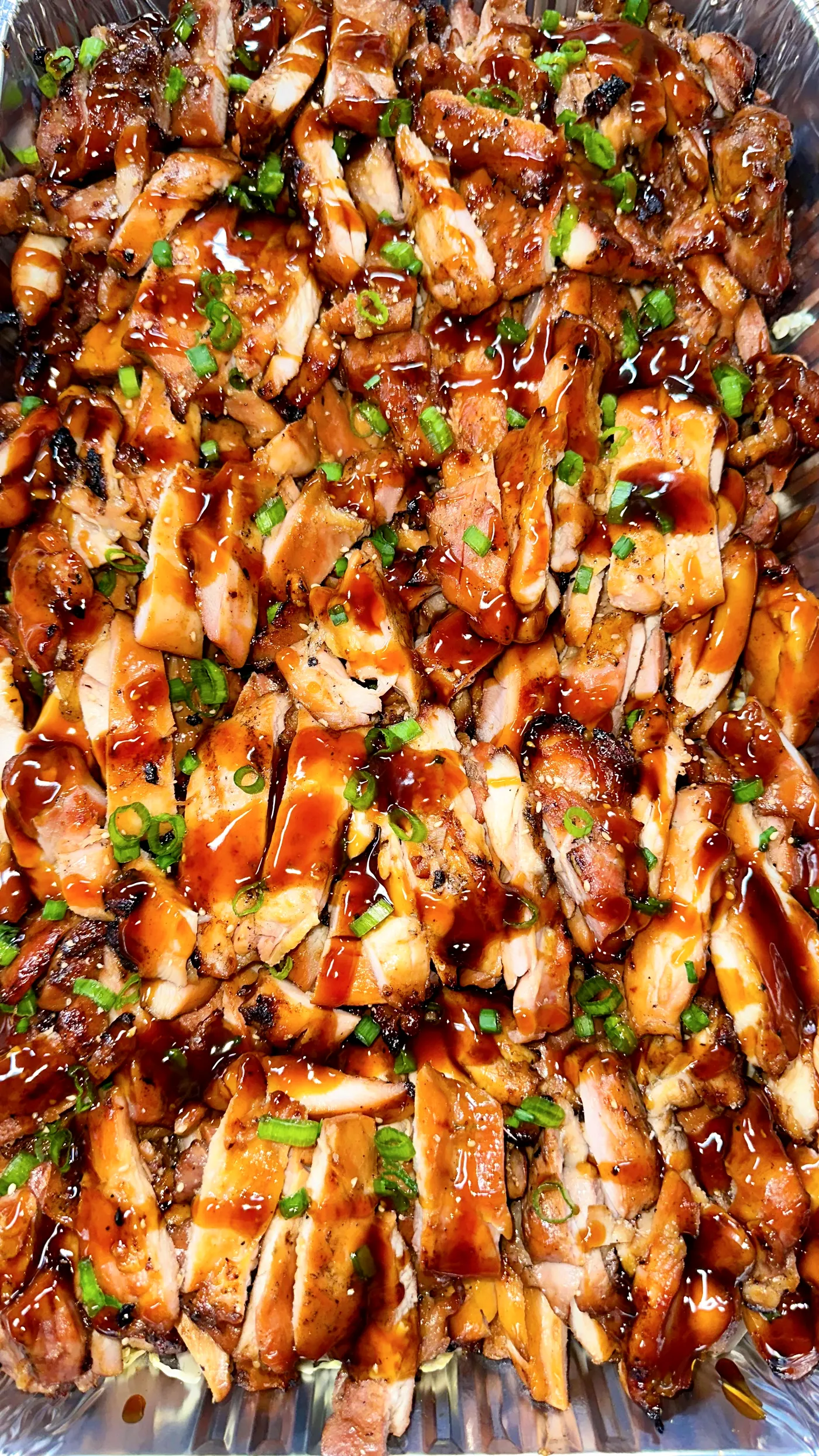 Tray of freshly grilled teriyaki chicken with green onion