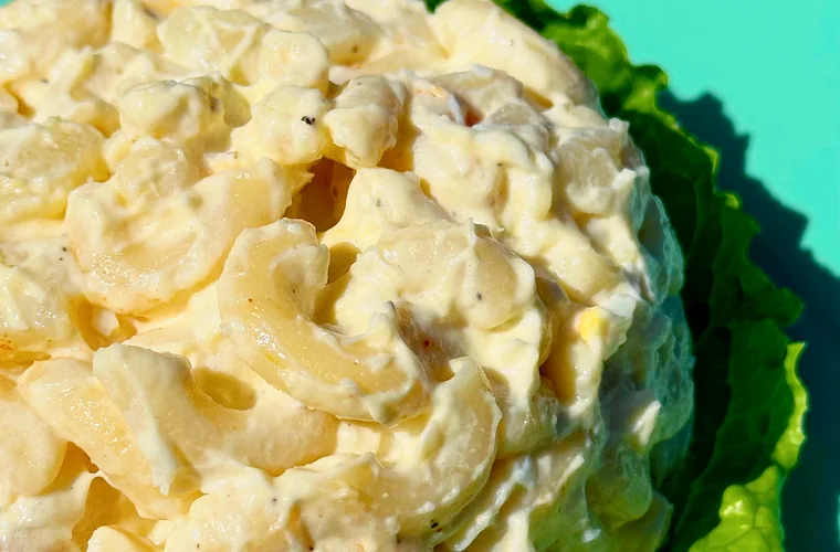 Creamy scoop of macaroni salad on lettuce